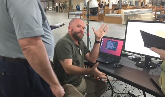 man sitting in front of a laptop with ubuntu on it speaking