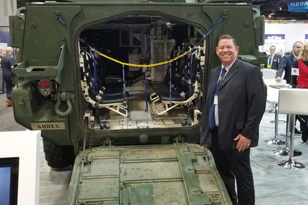 man behind a vehicle for the army with seats in the open back