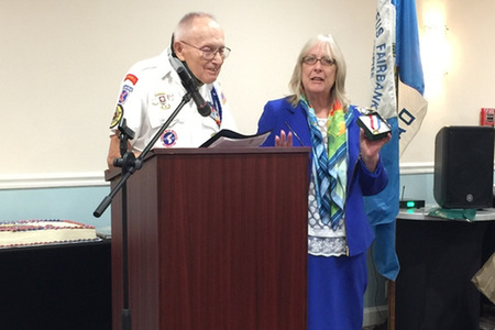 old man and a woman at a podium smiling for a photo